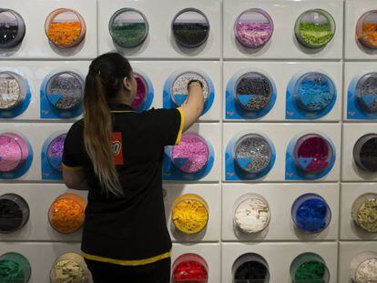 Una empleada coloca piezas de Lego en los estantes de una tienda