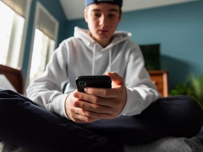 Un adolescente utiliza su móvil.