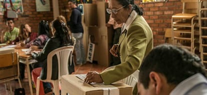 Una mujer depositando su voto.