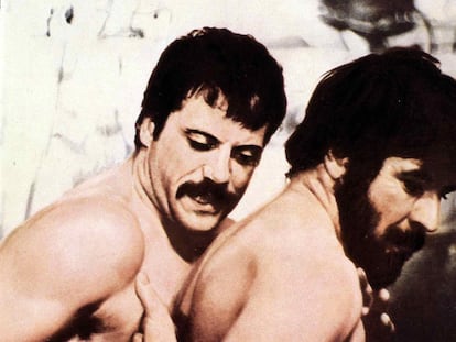 A pesar de que los desnudos femeninos llegaron a la pantalla antes que el sonoro, hubo que esperar a 1969 para ver el primer cuerpo masculino libre de ropajes. Tardó en llegar, pero lo hizo por partida doble. 'Mujeres enamorada's, la novela de D.H. Lawrence llevada al cine por Ken Russell, uno de los maestros de Stanley Kubrick, mostró por primera vez en pantalla los cuerpos desnudos de dos hombres: Oliver Reed y Alan Bates. Y no sólo desnudos, sino vigorosamente entrelazados. La excusa: una escena de lucha entre dos amigos iluminada únicamente por el fuego de una chimenea. El contexto: una historia en la que las relaciones entre dos hermanas y sus respectivas parejas sirve para trazar un fresco sobre el amor, el deseo y la lucha de clases. Tras su guión se encontraba el legendario activista gay Larry Kramer, responsable de 'The normal heart', que en su afán por preservar el espíritu (y el homoerotismo) de la novela se las tuvo que ver con la censura y con los propios protagonistas. A medida que llegaba el día del rodaje de una escena que sabían se incrustaría para bien o para mal en la historia del cine, tanto Bates como Reed empezaron a manifestar distintas “dolencias”. "Ambos tenían certificados médicos para demostrarlo", confesó años después Ken Russell. Según el director, el equipo llegó a apostar que los actores no se presentarían a la grabación y cuando lo hicieron “recibieron un gran aplauso”. Kramer añade malicioso que cada cierto tiempo Oliver desaparecía del plató “para hacer que su pene pareciera más grande". Trucos del cine.