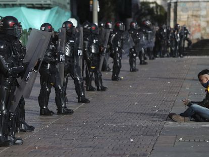 Un manifestante se sienta frente a una fila de policías, el 21 de septiembre de 2020 en Bogotá.