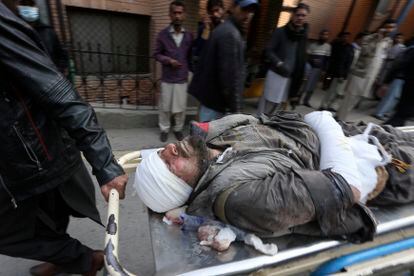 Trabajadores y voluntarios transportan víctima de la explosión ocurrida en una mezquita de Peshawar, este lunes 30 de enero.