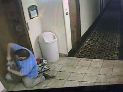 El hombre intenta liberar al perro de la cuerda que le tiene atrapado al ascensor.