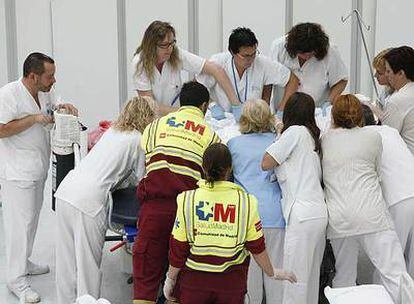 Un grupo de sanitarios traslada a un paciente del antiguo Puerta de Hierro al nuevo hospital, en Majadahonda.