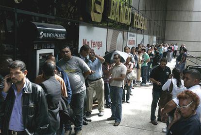 Ahorradores venezolanos hacen cola ante una sucursal del Banco Federal en Caracas el pasado 14 de junio.