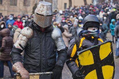 Los manifestantes con unas protecciones improvisadas, se preparan para un enfrentamiento con la policía en el centro de Kiev, Ucrania, lunes, 20 de enero de 2014. 