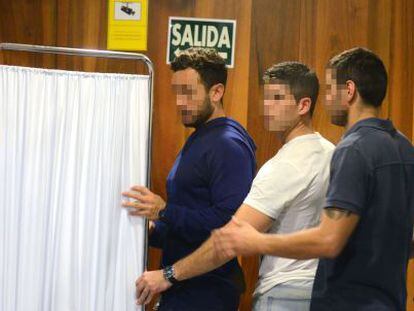 Tres agentes acuden a saludar a los polic&iacute;as detenidos por el crimen de Cala Cortina (tras el biombo) el pasado 8 de octubre en un juzgado de Cartagena