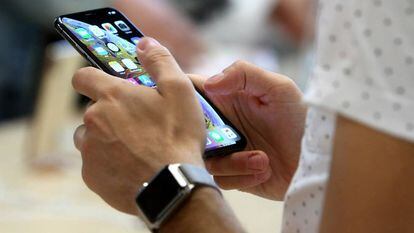 Un usuario sostiene un iphone en la tienda de Apple de la Puerta del Sol de Madrid.