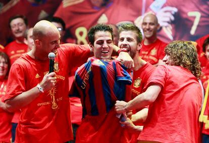 Puyol y Piqué colocan la camisetan del Barcelona a Cesc durante la celebración del Mundial.