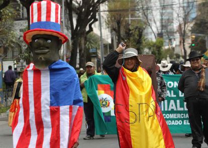 Seguidores del presidente de Bolivia, Evo Morales, protestan cubiertos con banderas ante la embajada de EE UU en La Paz (Bolivia).