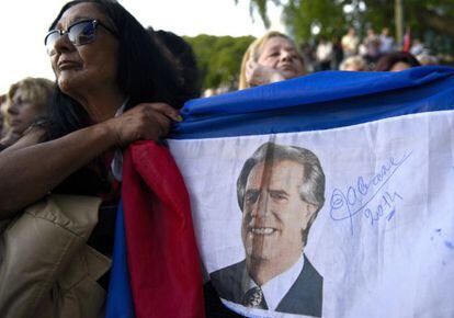 Una mujer sostiene una bandera con la imagen de Tabar&eacute; V&aacute;zquez. 