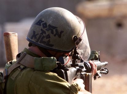 Un soldado israelí apunta con su fusil M-16 a los palestinos que le disparan piedras, en Belén, en 2000.