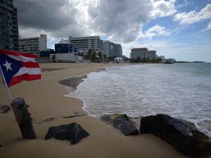 Una bandera puertorriqueña ondea en una playa vacía en Ocean Park, en San Juan, Puerto Rico, el jueves 21 de mayo de 2020.