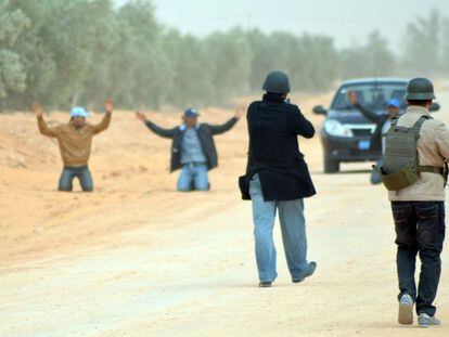 Policías tunecinos detienen a los pasajeros de un vehículo que circulaba por una zona prohibida junto a la frontera libia, el 10 de marzo.