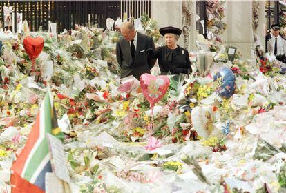 La reina Isabel II y el duque de Edimburgo caminan a las puertas del palacio de Buckingham el 5 de septiembre de 1997, entre los ramos de flores puestos como tributo a Diana tras su muerte.