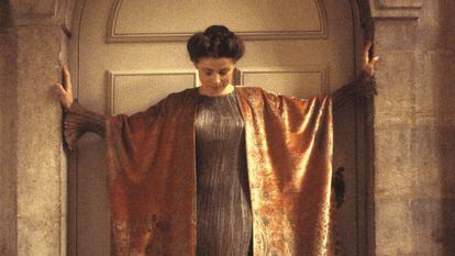 Modelo con abrigo tres cuartos de terciopelo de seda con motivos cretenses sobre vestido Delphos gris y teja. 