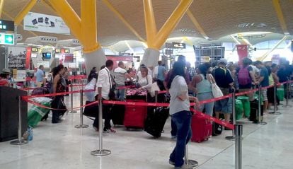 Los venezolanos afectados por la cancelación de su vuelo se forman para abordar en el aeropuerto de Madrid.