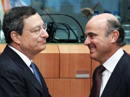 El presidente del BCE, Mario Draghi, junto a Luis de Guindos en una reuni&oacute;n en Bruselas en julio de 2012
