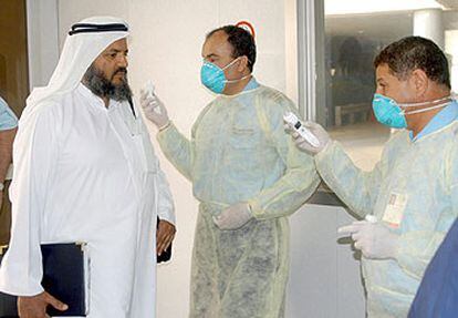 Un viajero es sometido a un control sanitario en el aeropuerto internacional de Kuwait para prevenir la neumonía.