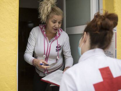 Cristina, voluntària de Creu Roja, porta menjar a Yoslen Garrido, al barrio de Nou Barris. 