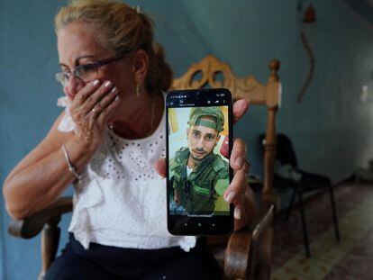 Marilin Vinent muestra una foto de su hijo Dannys Castillo en uniforme militar en Almar, Cuba, el 6 de septiembre 2023.