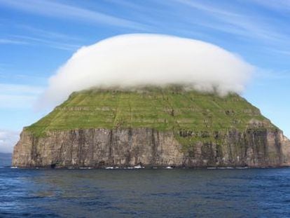 La peque&ntilde;a isla rocosa Litla D&iacute;mun, en las islas Feroe, con un sombrero de nubes. 