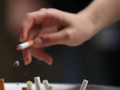 Una mujer fuma. En vídeo, Cataluña anuncia que prohibirá fumar en los coches privados.