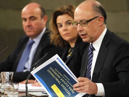 El ministro de Hacienda, Cristóbal Montoro, la vicepresidenta Soraya Sáenz de Santamaría, y el ministro de Economía, Luis De Guindos.