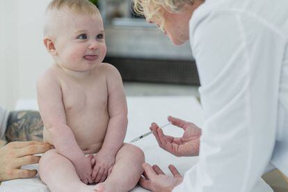 Un pediatra vacuna a un bebé. 
