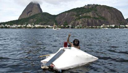 Una persona sin hogar, muestra su casa flotante construida con basura en Río de Janeiro, Brasil.