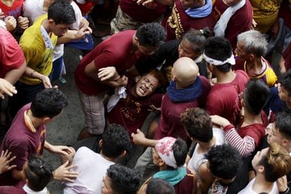 Los feligreses se arriesgan a ser aplastados por el gentío para rozar la talla o alguna de las dos maromas que arrastran el carro.