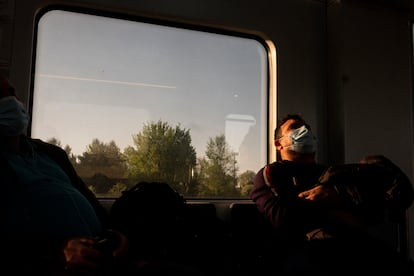 Un pasajero duerme en el interior de un vagón de la línea C-7 de Renfe que une Alcalá de Henares y Atocha.