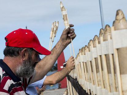 Dos hombres preparan las bombas en honor a la Virgen del Carmen en el puerto de O Grove (Pontevedra).