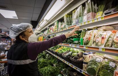 Una empleada de un supermercado en la Colonia Roma, Ciudad de México, reorganiza un estante.