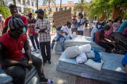Temporeros en la plaza de España, este miércoles en Lepe durante la manifestación junto a los colchones donde duermen desde hace 21 días, / PACO PUENTES