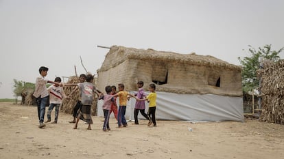 Un grupo de niños desplazados en Yemen juega junto a un refugio de emergencia de Tehama en Hudaydah. Estos innovadores refugios se construyen tejiendo la fibra de palmeras locales y se adaptan muy bien al clima de la región, aislando y protegiendo los edificios.