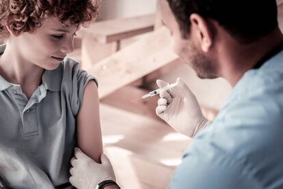 Un médico vacuna a un niño.