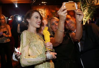 La actriz Emma Stone posa para un selfie con otros invitados a la fiesta del Gobernador tras la celebración de la gala