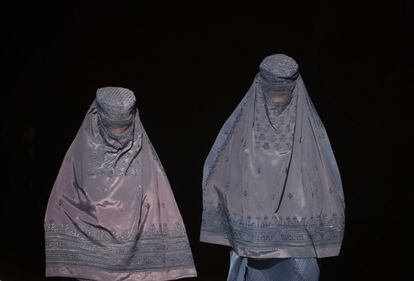 Dos mujeres afganas vestidas con burka salen de una tienda en un mercado en Mazar-i-Sharif.