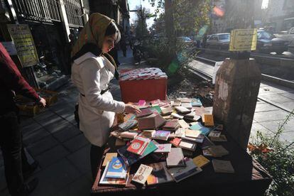 Una iran&iacute; hojea libros en Teher&aacute;n.