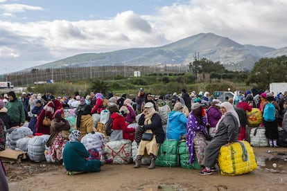 Un grupo de porteadoras espera al autobús que les llevará desde los polígonos de Melilla a la frontera, en el Barrio Chino.
