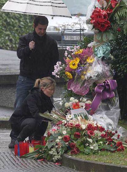 María, hija de Ignacio Uria,  coloca unas flores en el lugar donde fue asesinado su padre.