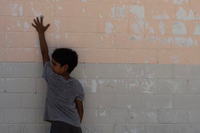 A child shows the mark of a bullet on the school wall after drone attacks and clashes that have left one person dead in the Nuevo Caracol community.