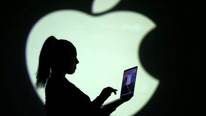Silueta del logotipo de Apple con una mujer y un ordenador.