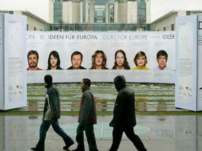 Varias personas pasan ante un cartel promocional de Alemania y Europa  colocado delante de la Cancillería ayer en Berlín.