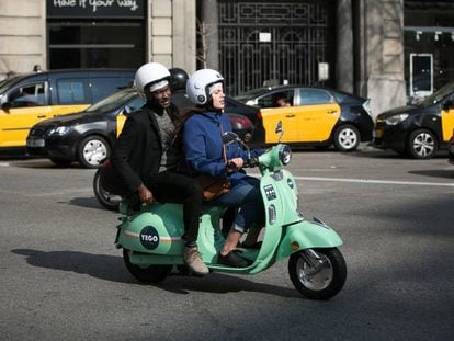 Usuaris d'una moto de lloguer per minuts, a Barcelona. 