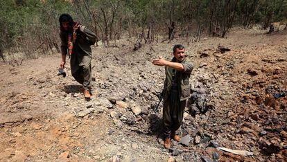 Milicianos del Partido de los Trabajadores del Kurdistán (PKK) inspeccionan un cráter causado por los bombardeos de los aviones del Ejército turco.
