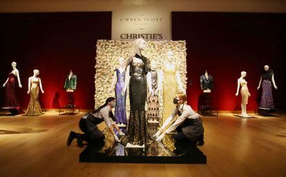 Christie's staff touch up the mannequins with the L'Wren Scott garments sold at auction in London.