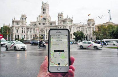 App de Uber en un teléfono móvil en la madrileña plaza de Cibeles