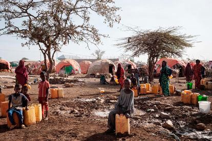 La gente espera a coger agua con contenedores en un campamento para desplazados en Baidoa (Somalia), en febrero de 2022.